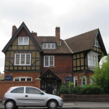 Photo of the exterior of tudor-style building 92 Woodstock Road, with a silver car in the foreground